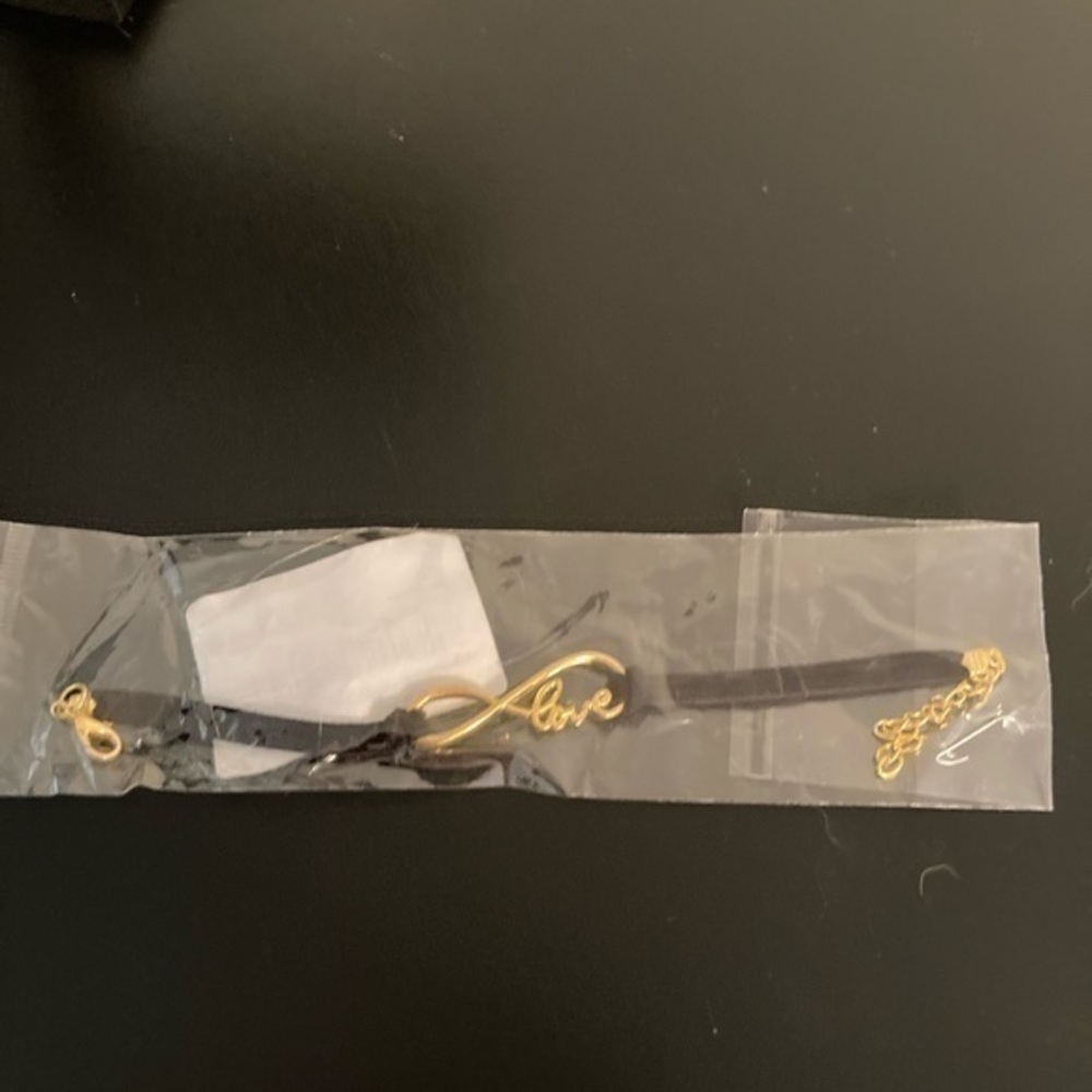 Still in plastic. Bracelet with infinity love golden design.